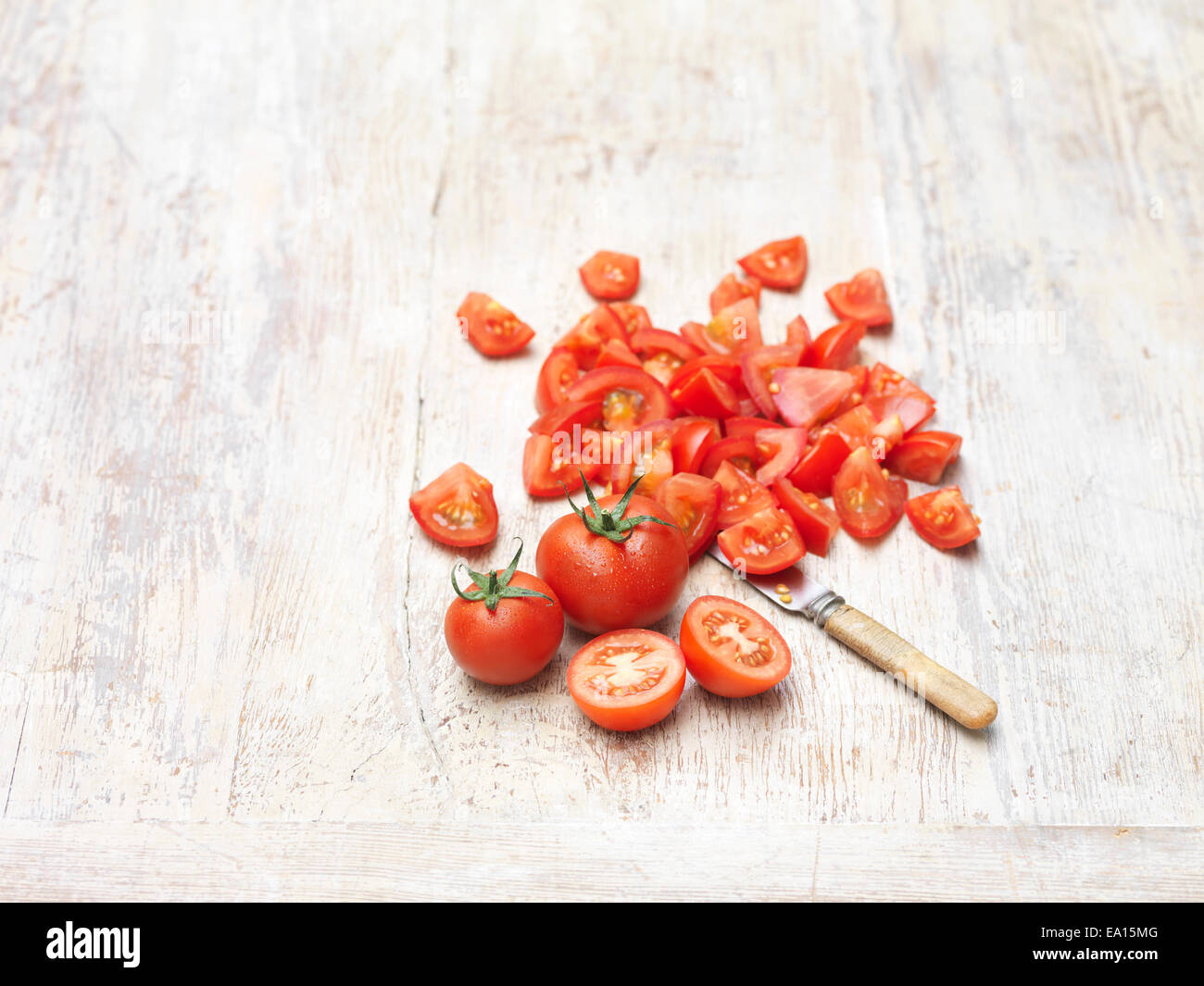 Whole and chopped red juicy sweet tomatoes, knife Stock Photo