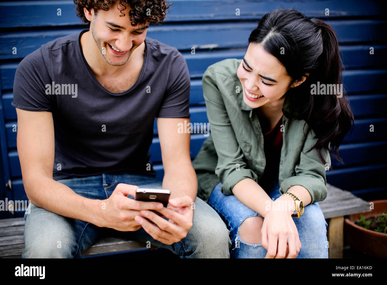Couple laughing at phone message Stock Photo