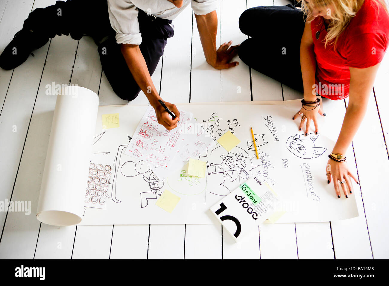 Graphic designers brainstorming on floor Stock Photo