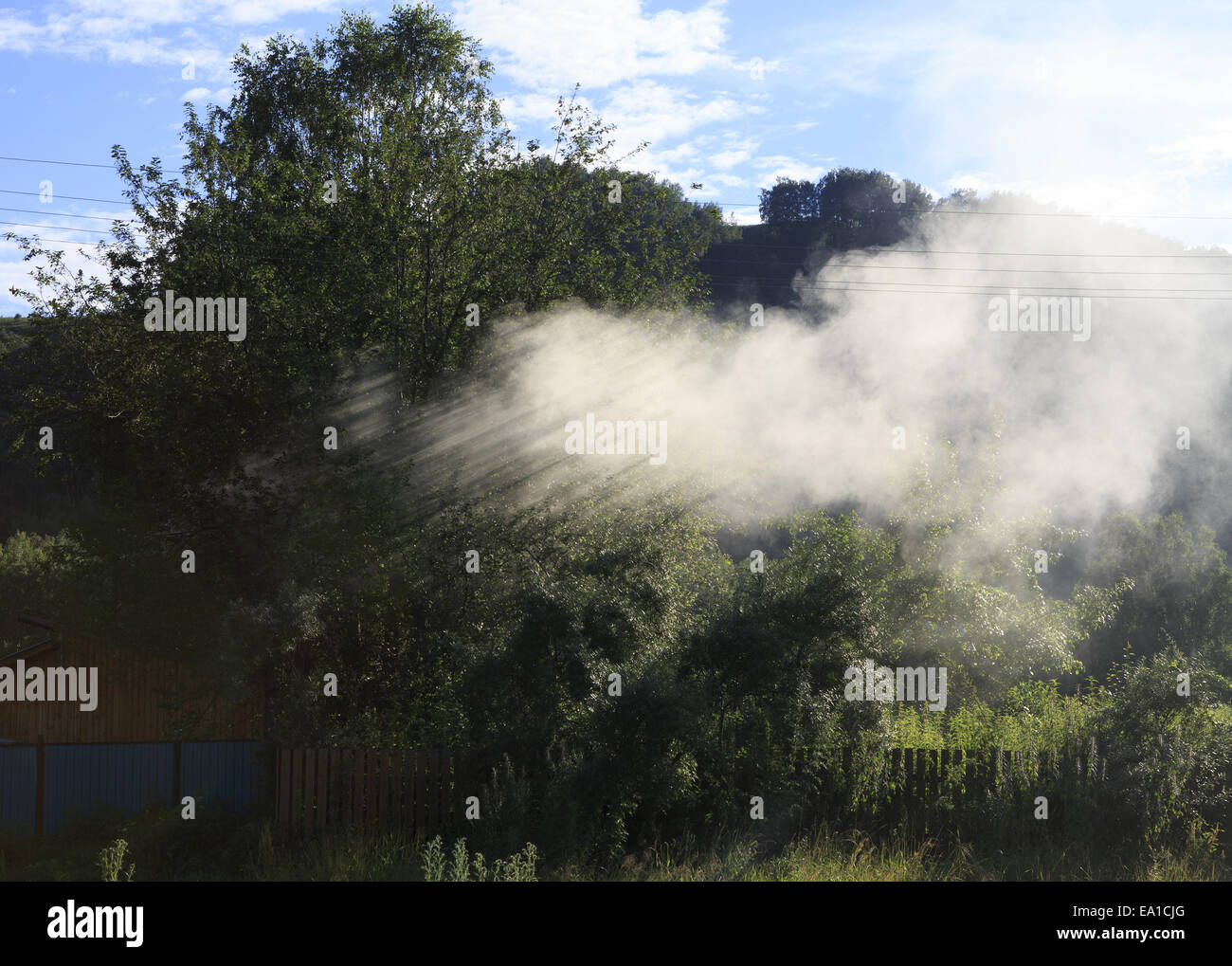 Sunrays through the smoke in the village. Stock Photo
