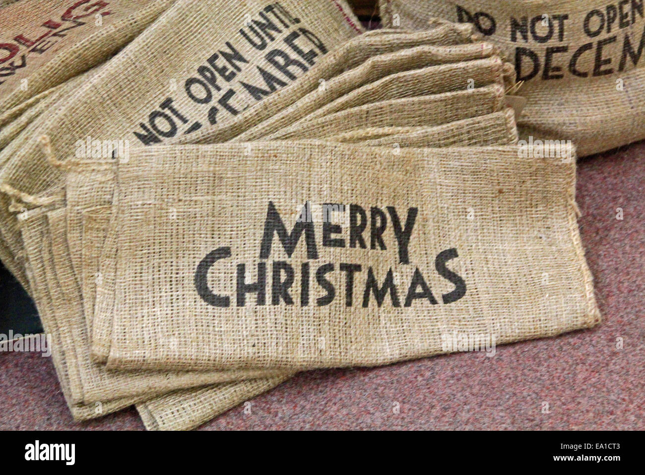 Large pile of hessian sacks with Christmas messages symbolizing Christmas, stockings and Santa delivering presents Stock Photo