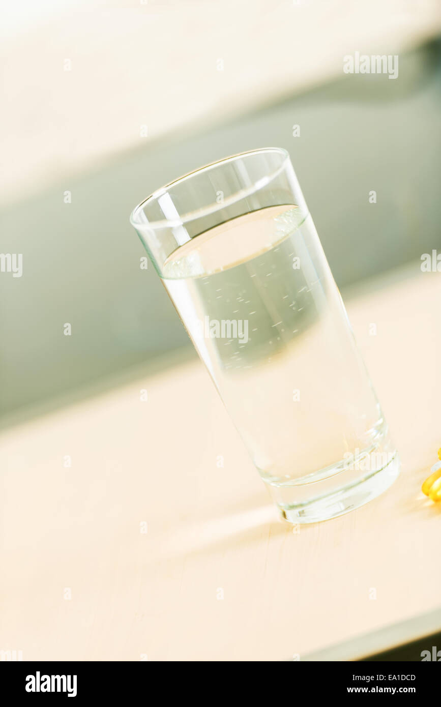 Pills and glass of water angled Stock Photo