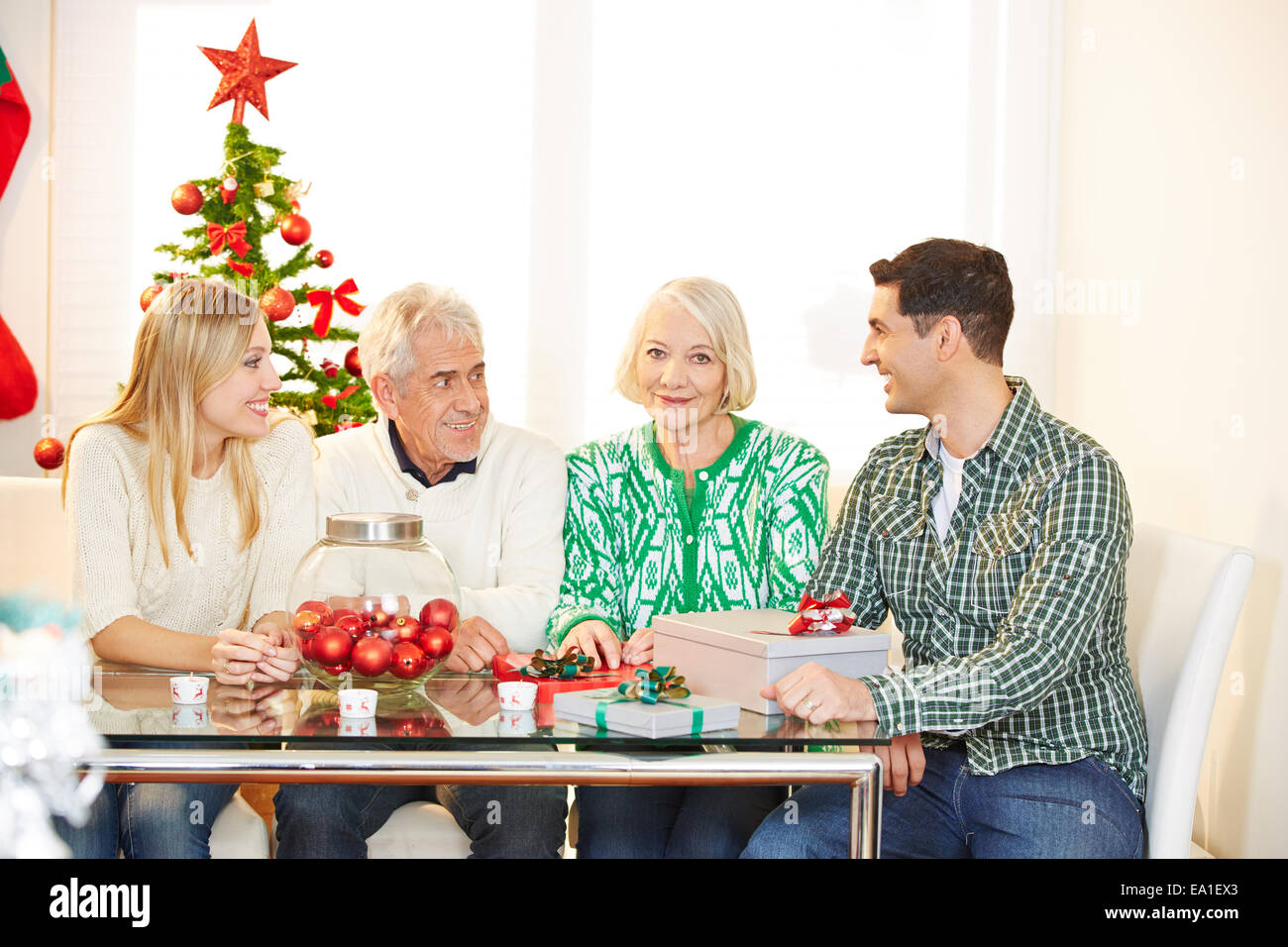 Family with seniors celebrating christmas with gifts and tree Stock