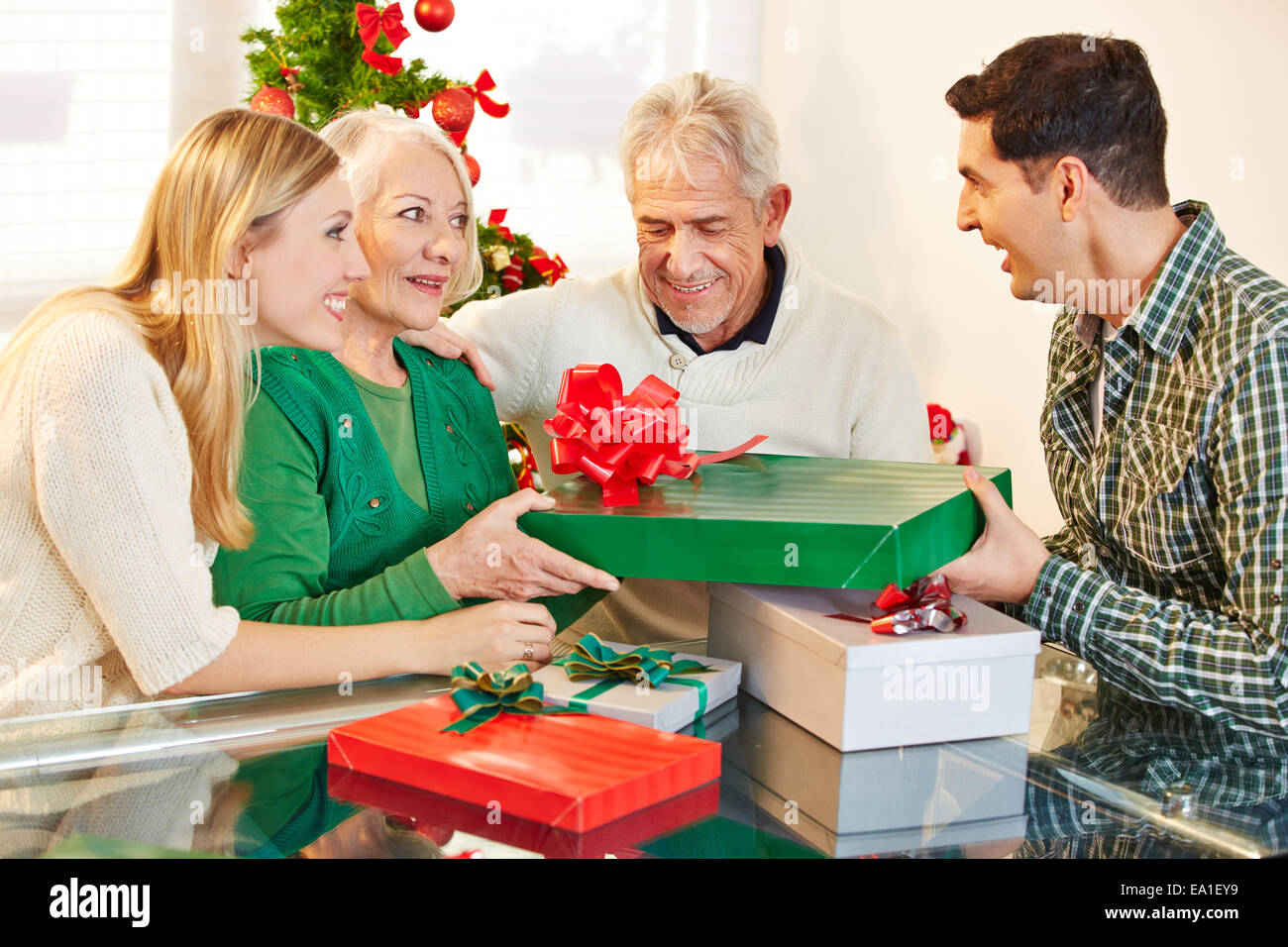 Man giving gift to his senior mother at christmas eve Stock Photo