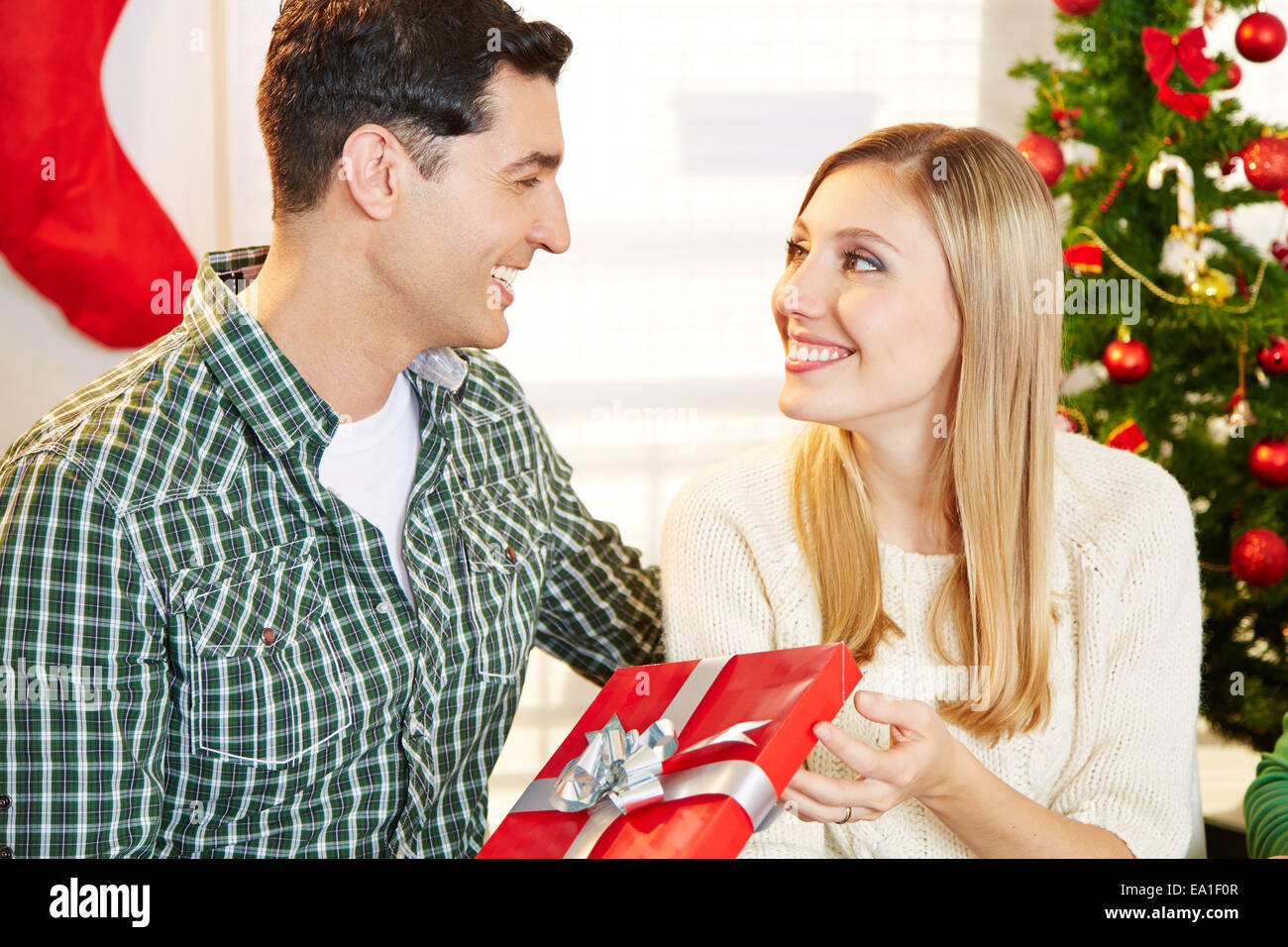 Happy couple with a red gift at christmas eve Stock Photo