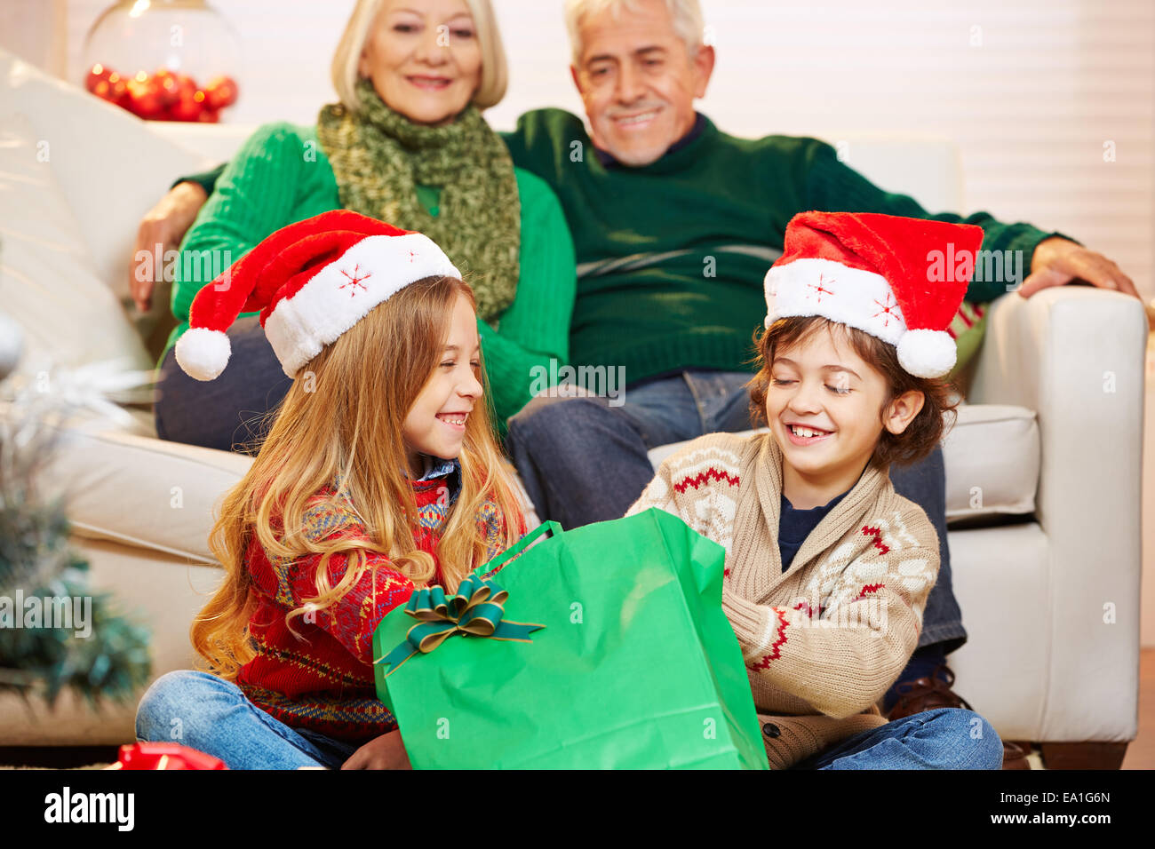 Children at grandfather and grandmother at christmas opening gifts Stock Photo