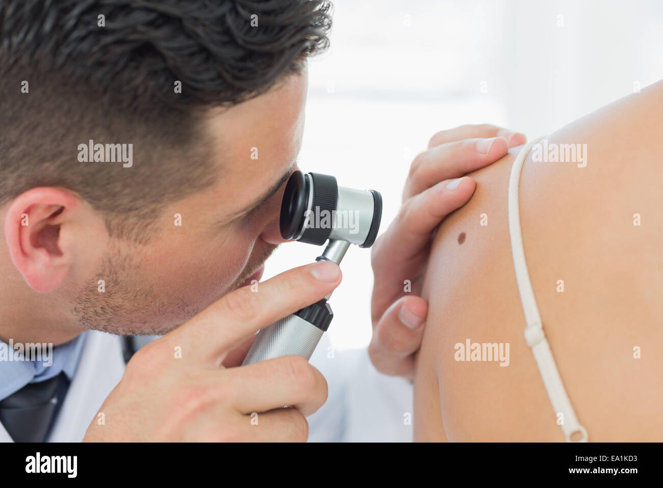 Dermatologist checking mole on woman Stock Photo
