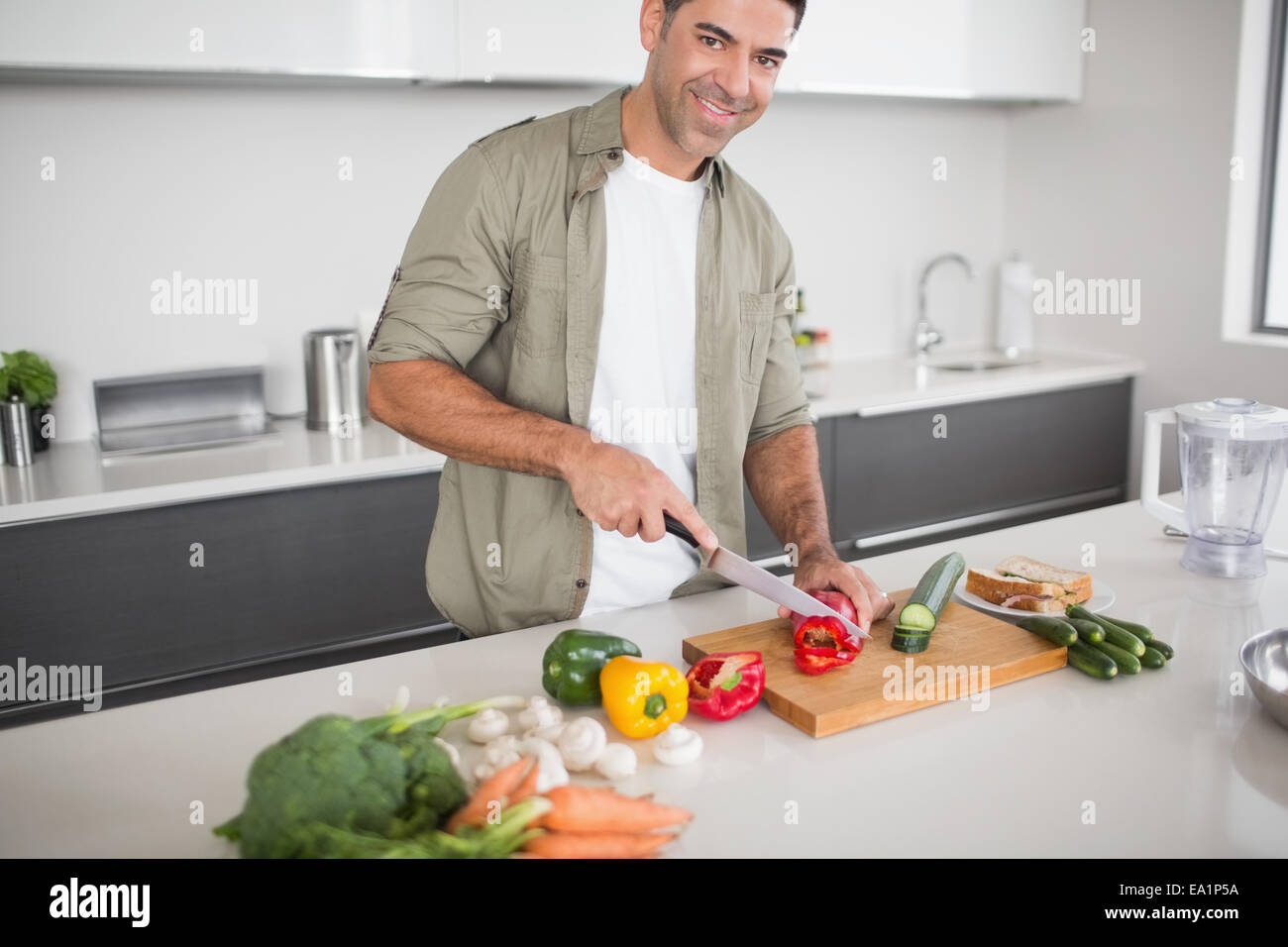 Smiling man chopping vegetables in kitchen Stock Photo - Alamy