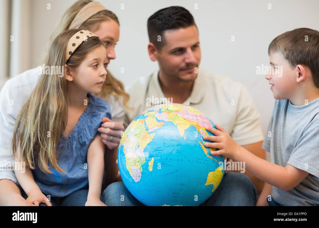 Family with globe in house Stock Photo Alamy