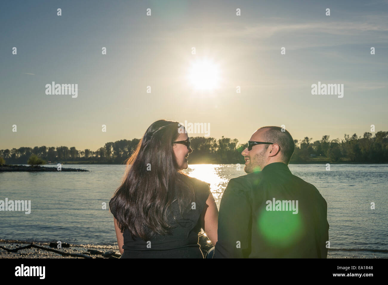 Couple sit at a river Stock Photo