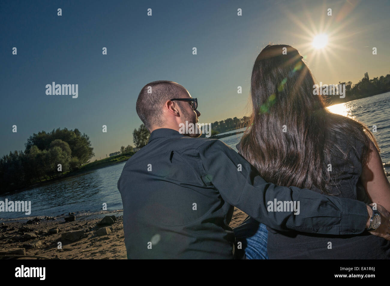 Couple sit at a river Stock Photo