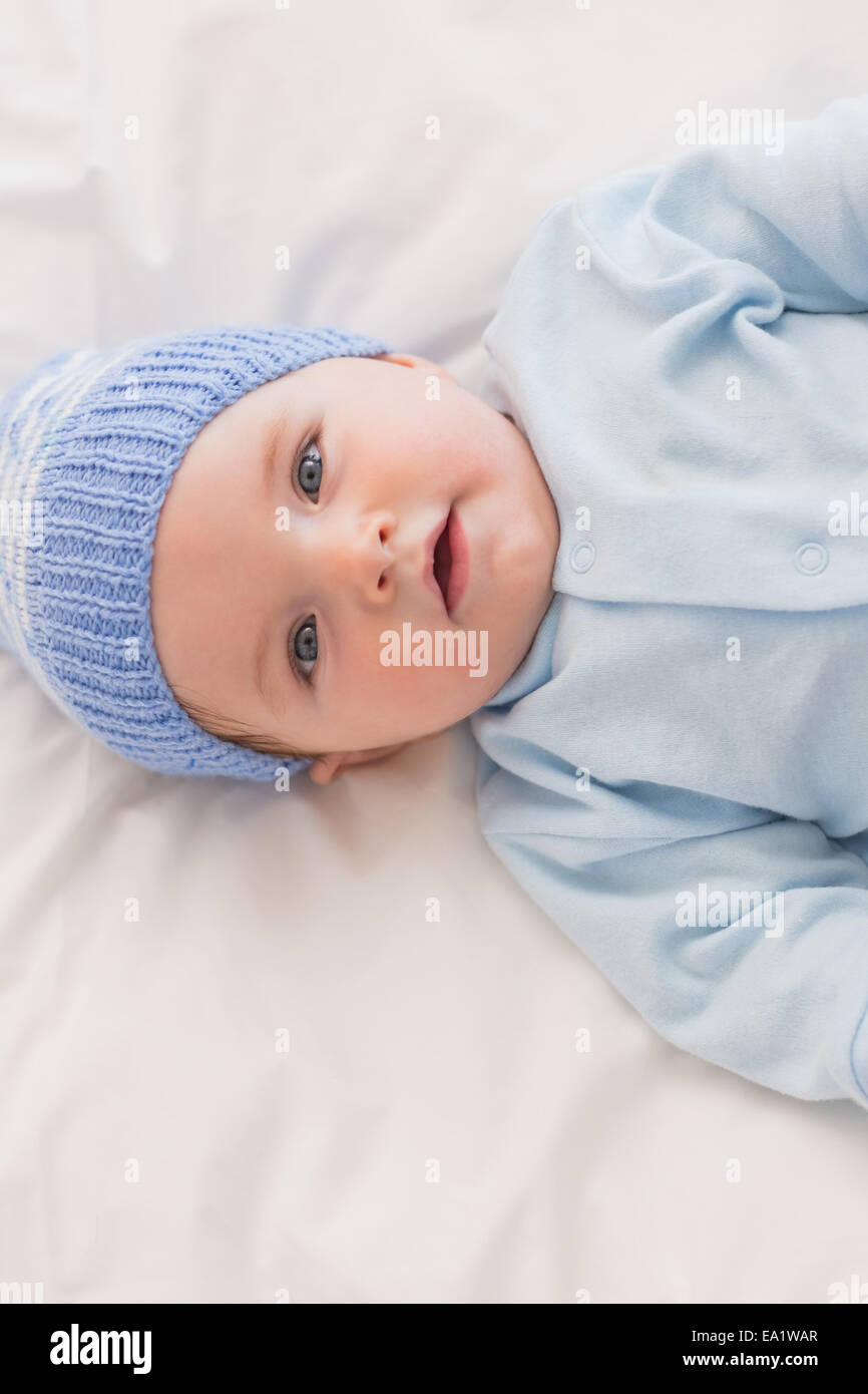 Innocent baby wearing knit hat in bed Stock Photo