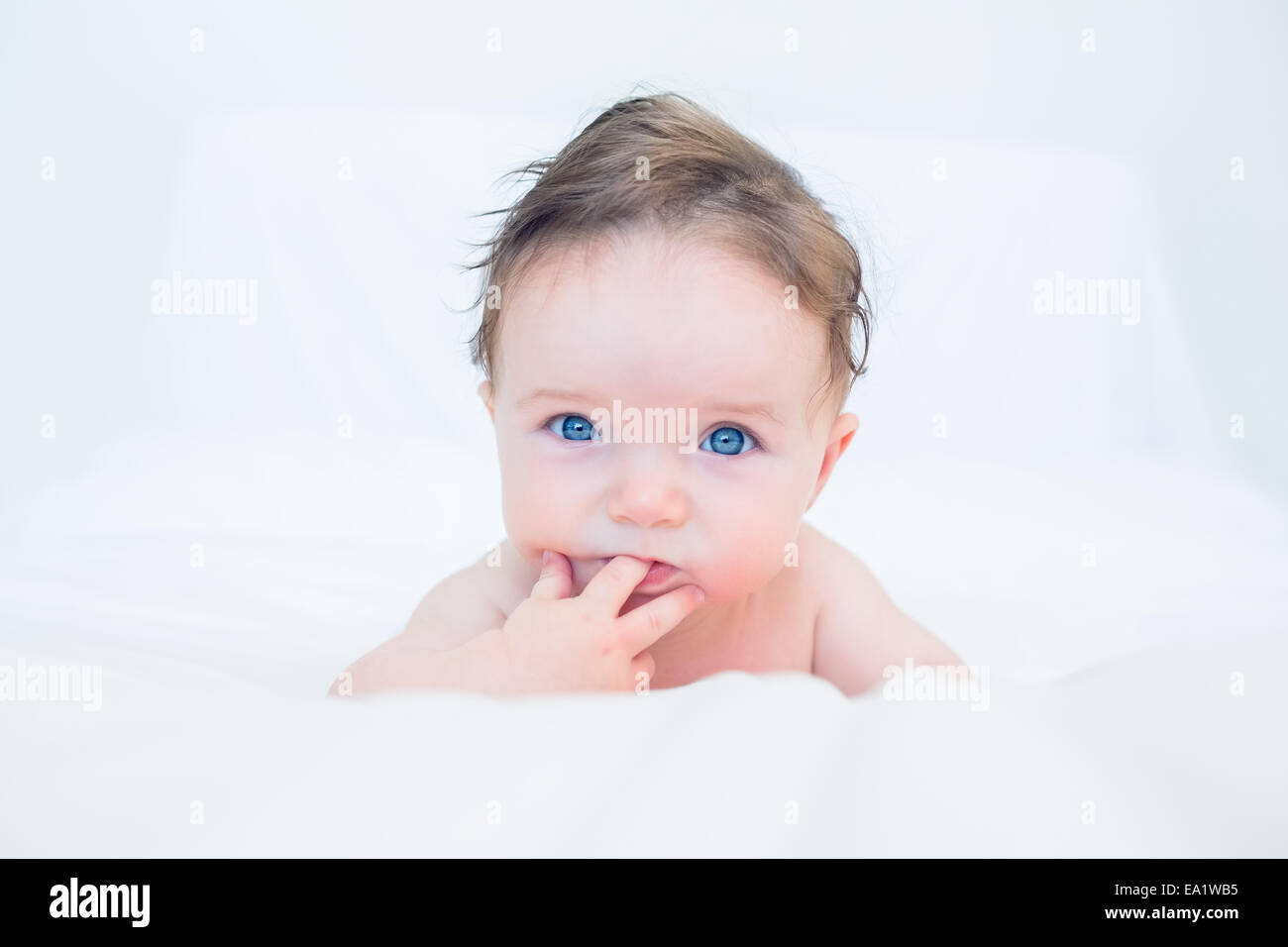 Cute baby with finger in mouth Stock Photo