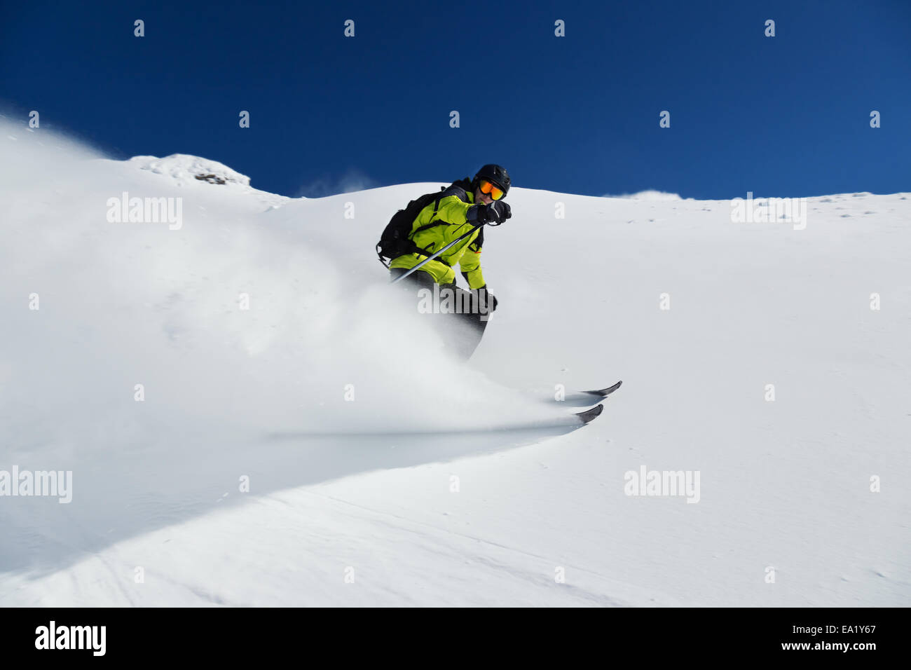 Alpine skier skiing downhill, blue sky on background Stock Photo
