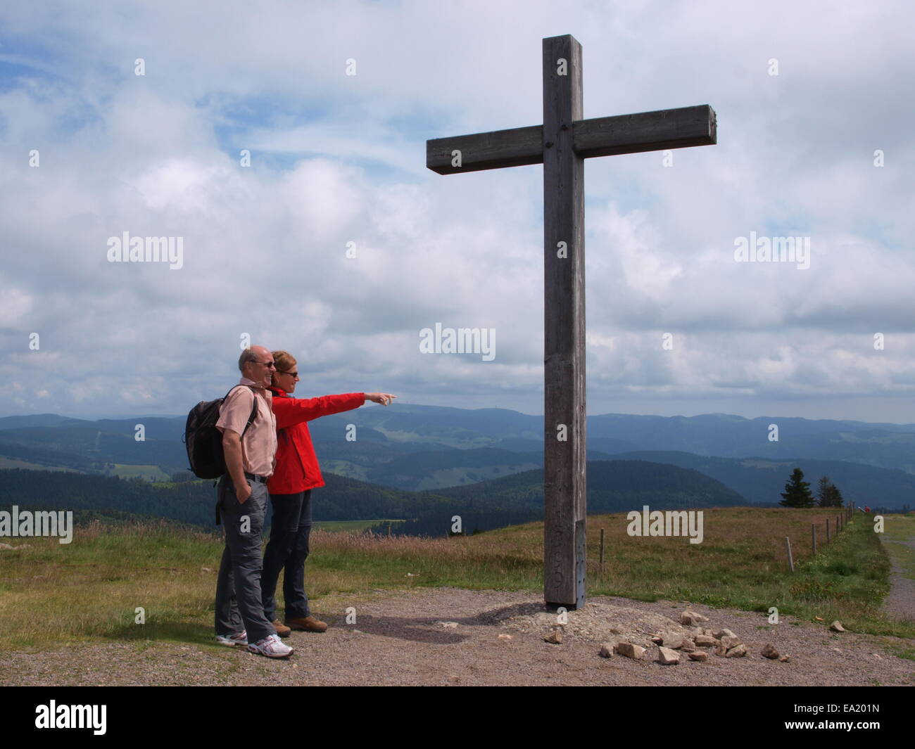Hiker near the hilltop cross at the Belchen Stock Photo