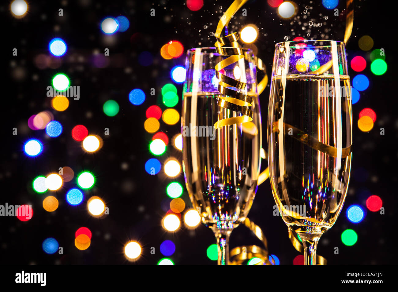Glasses of champagne on black background with blur colored spot lights. Concept of celebration Stock Photo