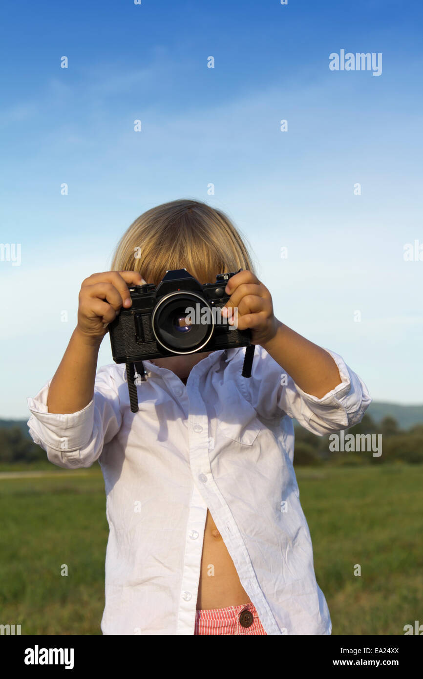 Young boy playing outdoors with vintage photo camera Stock Photo - Alamy