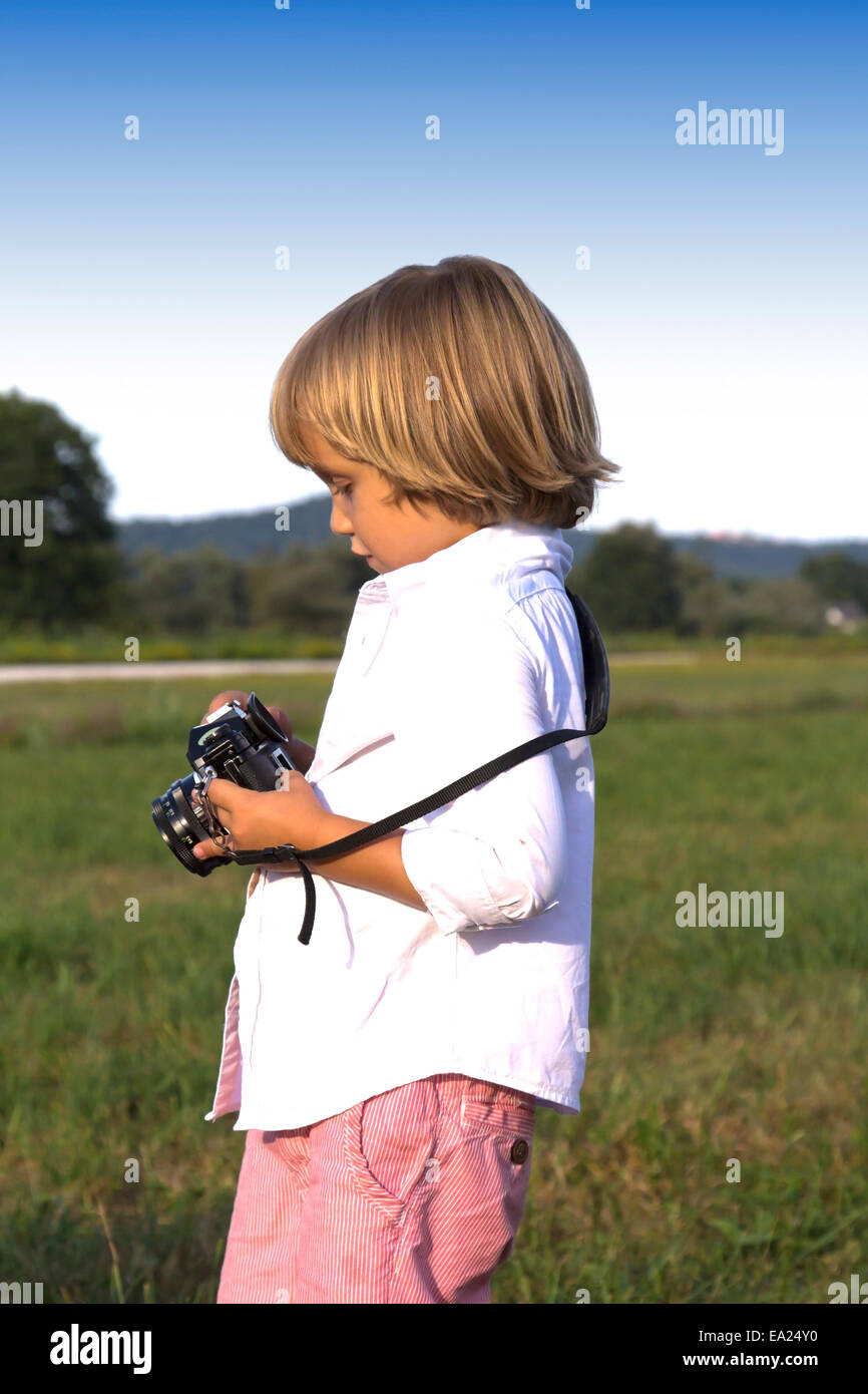 Young boy playing outdoors with vintage photo camera Stock Photo - Alamy