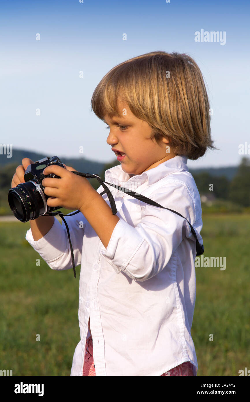 Young boy playing outdoors with vintage photo camera Stock Photo - Alamy