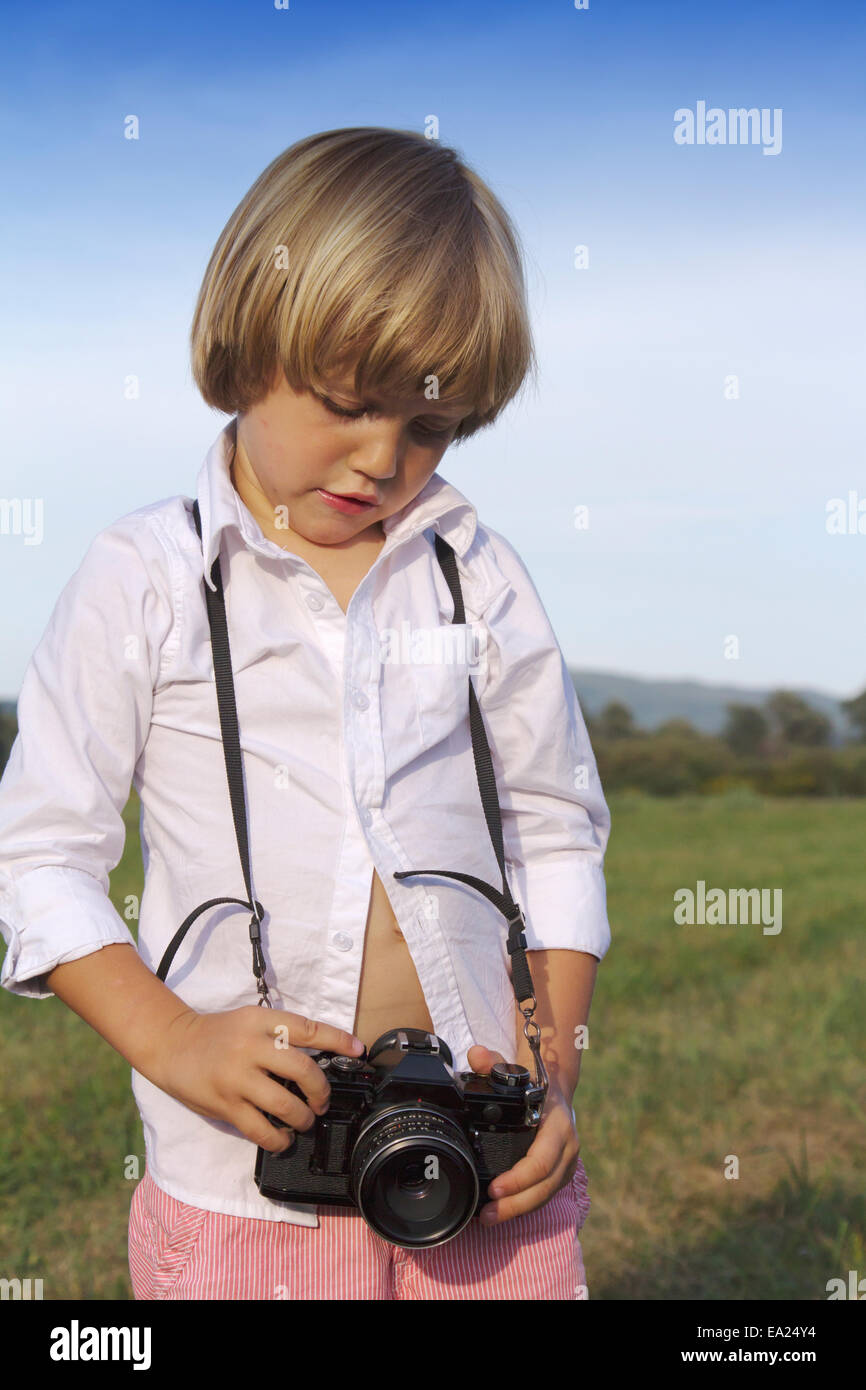 Young boy playing outdoors with vintage photo camera Stock Photo - Alamy