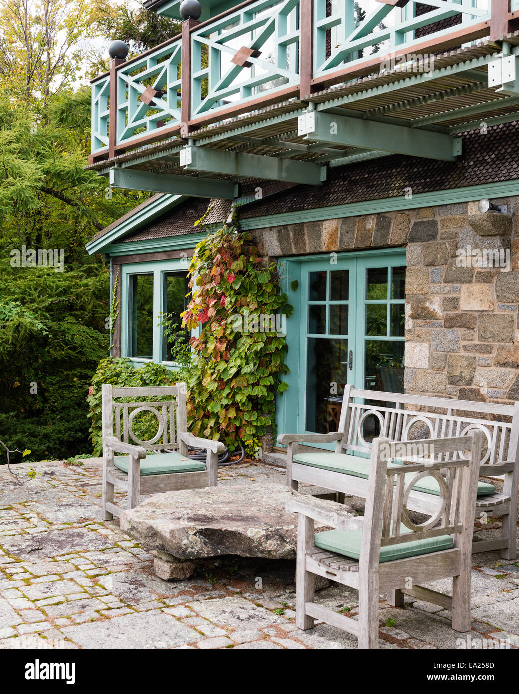 Teak balcony above granite terrace with outdoor furniture. Stock Photo