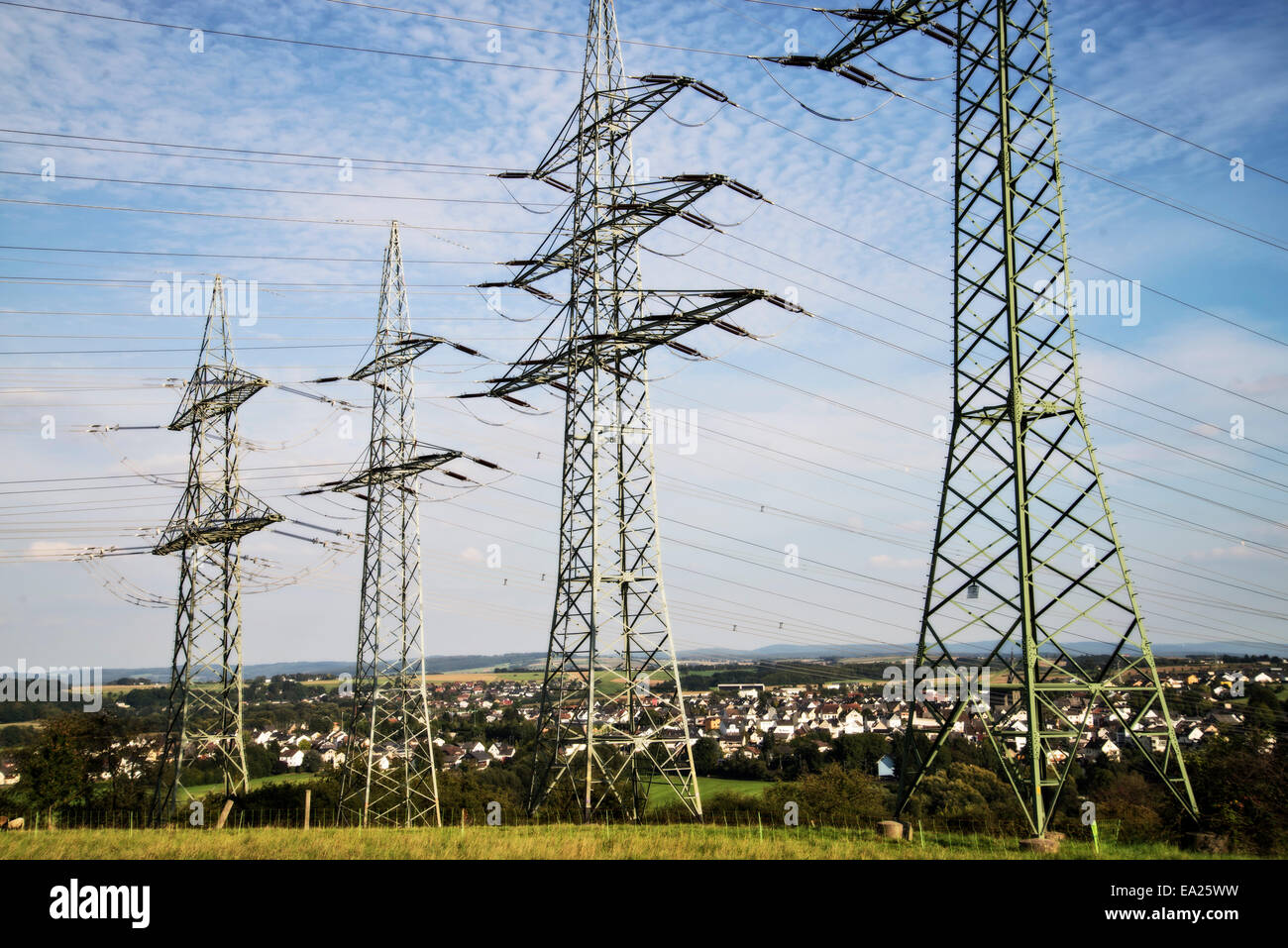 Four electricity pylons of a landline in a meadow near Limburg at the Lahn. Stock Photo