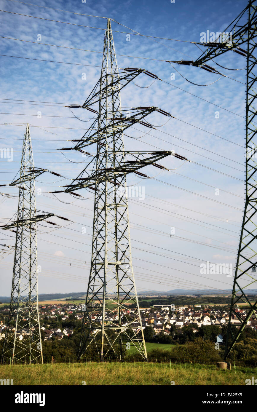 Three electricity pylons of a landline in a meadow near Limburg at the Lahn. Stock Photo