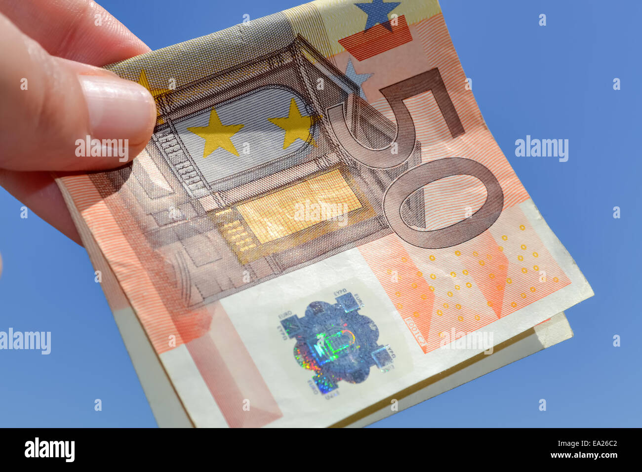 Closeup of single banknote of fifty euros with the sky as background Stock Photo