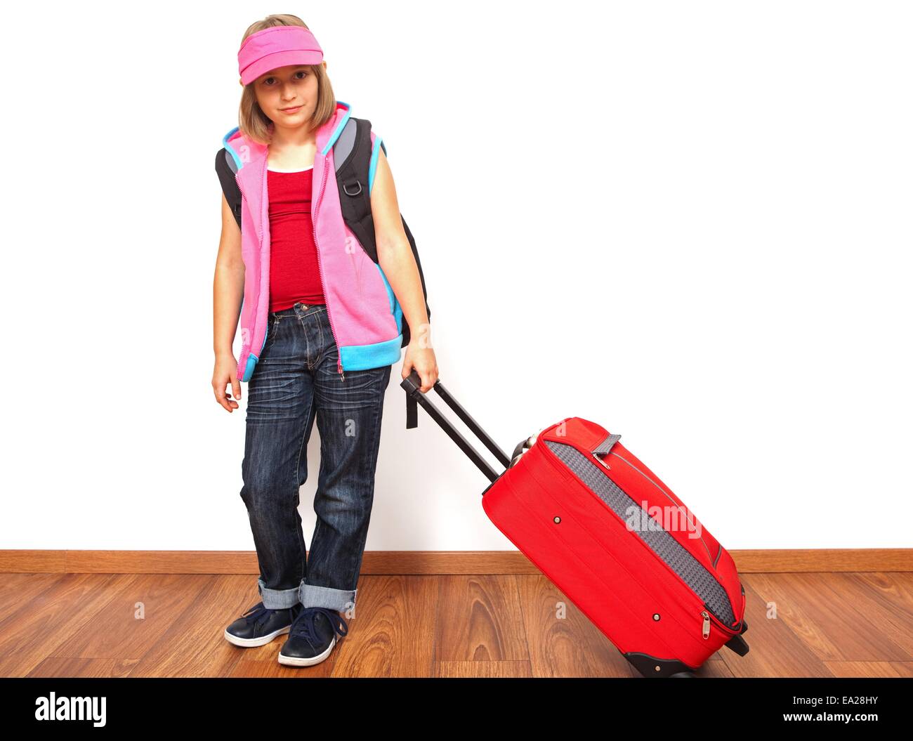 Little girl ready to travel, carrying red luggage Stock Photo