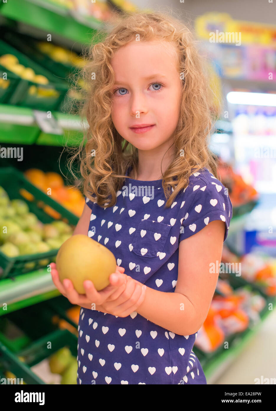 Little girl with apple in grocery store Stock Photo Alamy