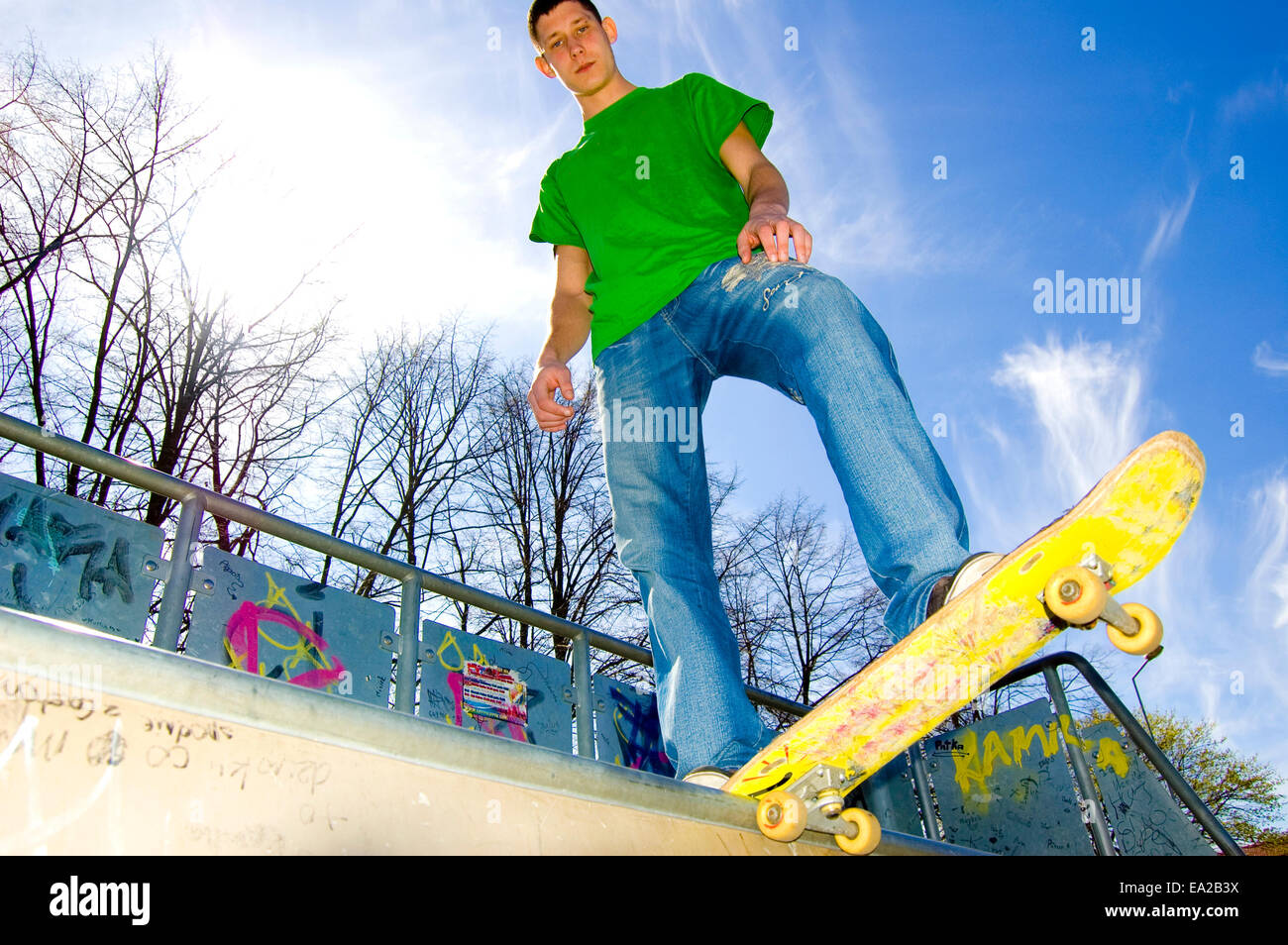 Sport conceptual image. Teenage skateboarder standing on the ramp with ...