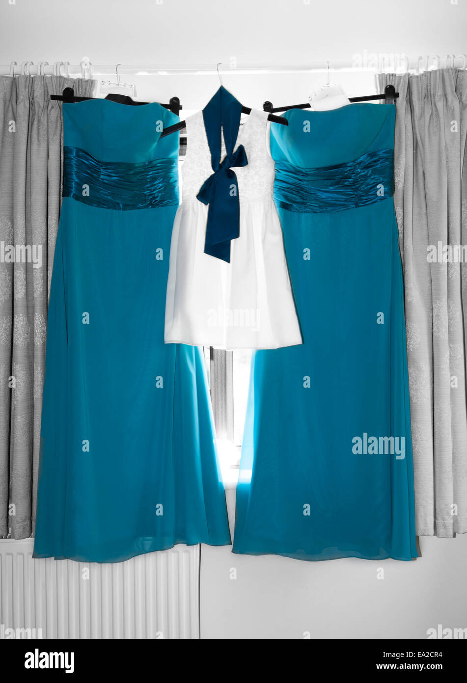 Peacock blue bridesmaids dresses hanging on a rail, waiting to be worn  Stock Photo - Alamy