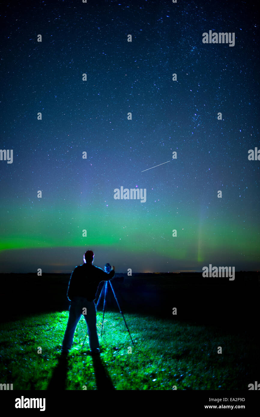 A photographer captures the Northern lights and shooting star, near Edmonton; Alberta Canada Stock Photo
