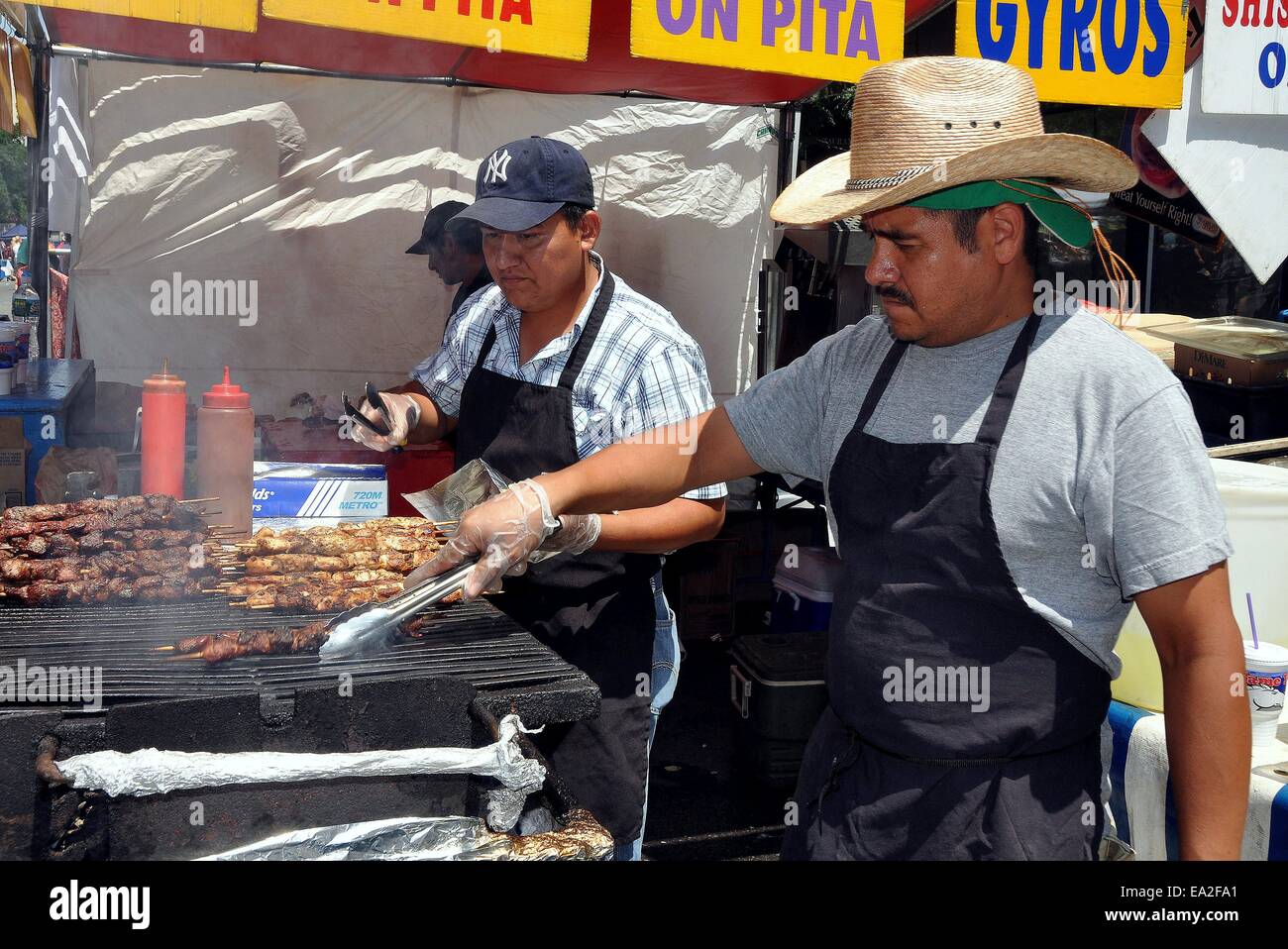 NYC:  Cooks barbecuing sizzling meats at a food booth at an Upper West Side street festival on Broadway Stock Photo