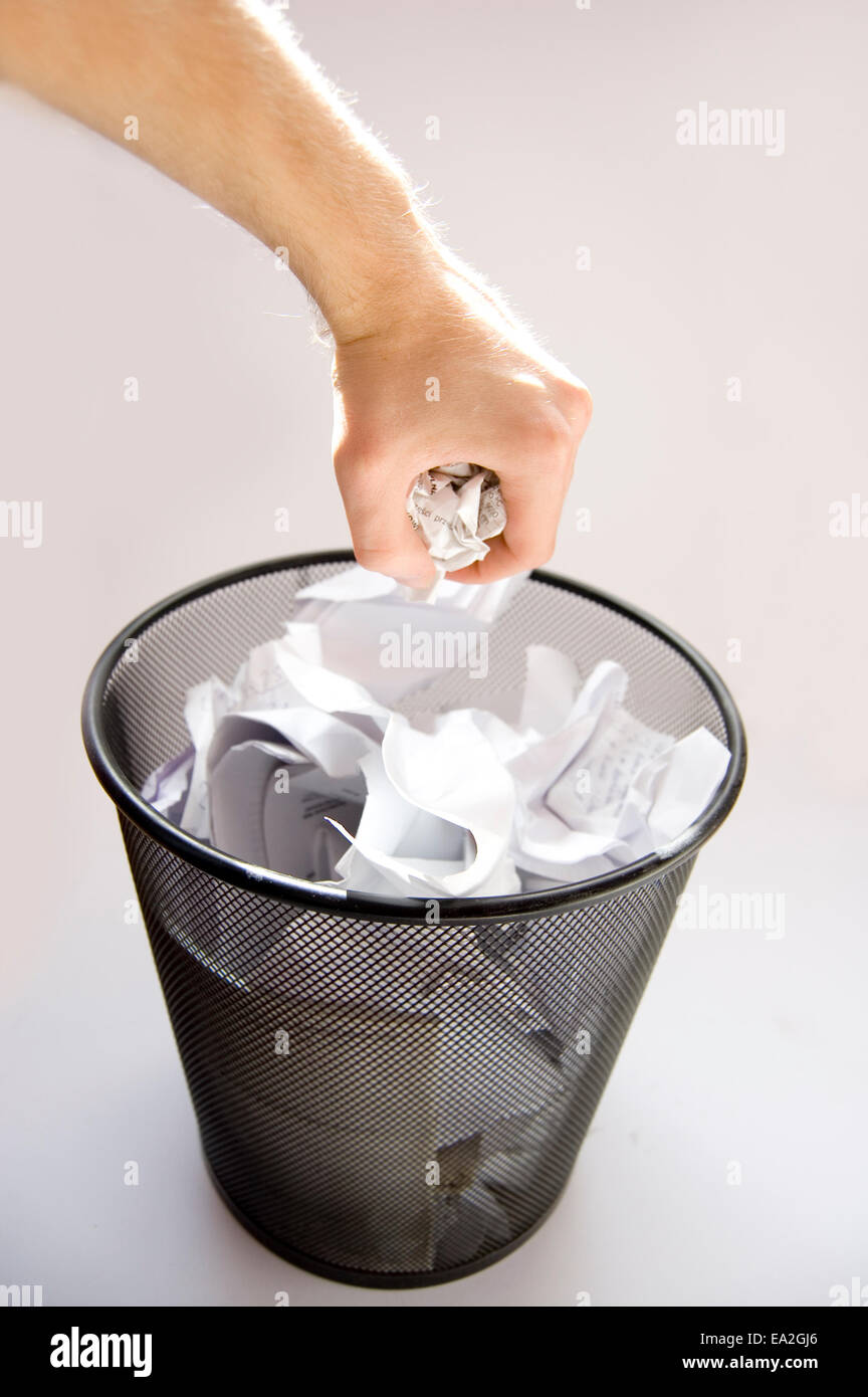 Garbage conceptual image. Man throws paper into a full garbage Stock