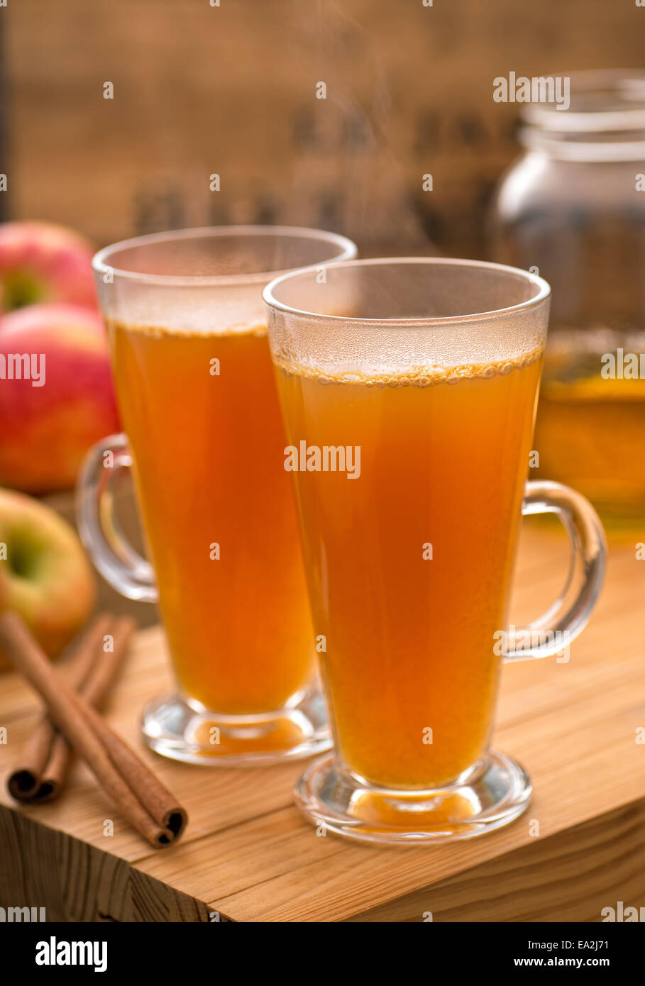 Hot and delicious apple cider with honeycrisp apples and cinnammon on a rustic wooden table