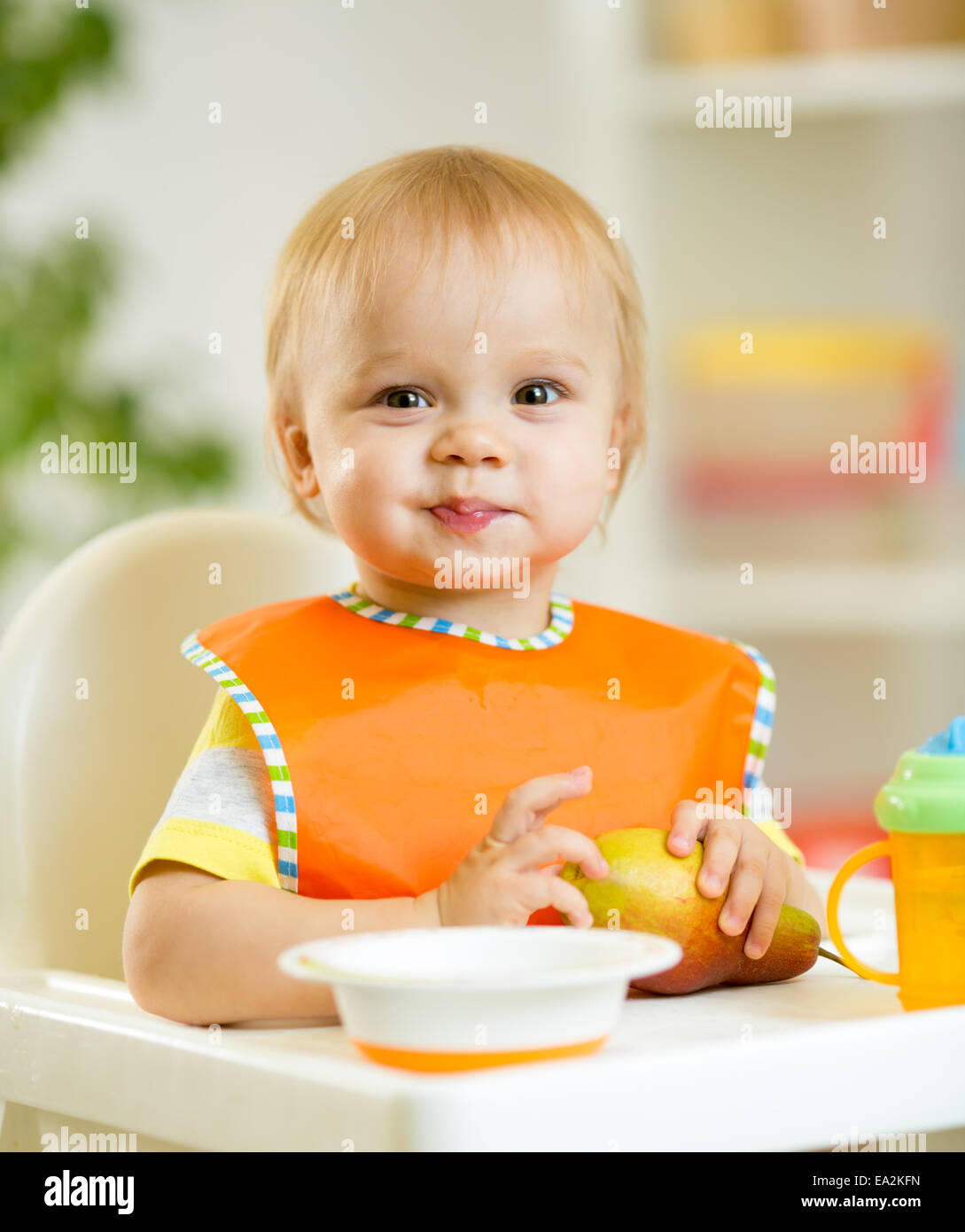 happy baby kid boy toddler eating itself with spoon Stock Photo