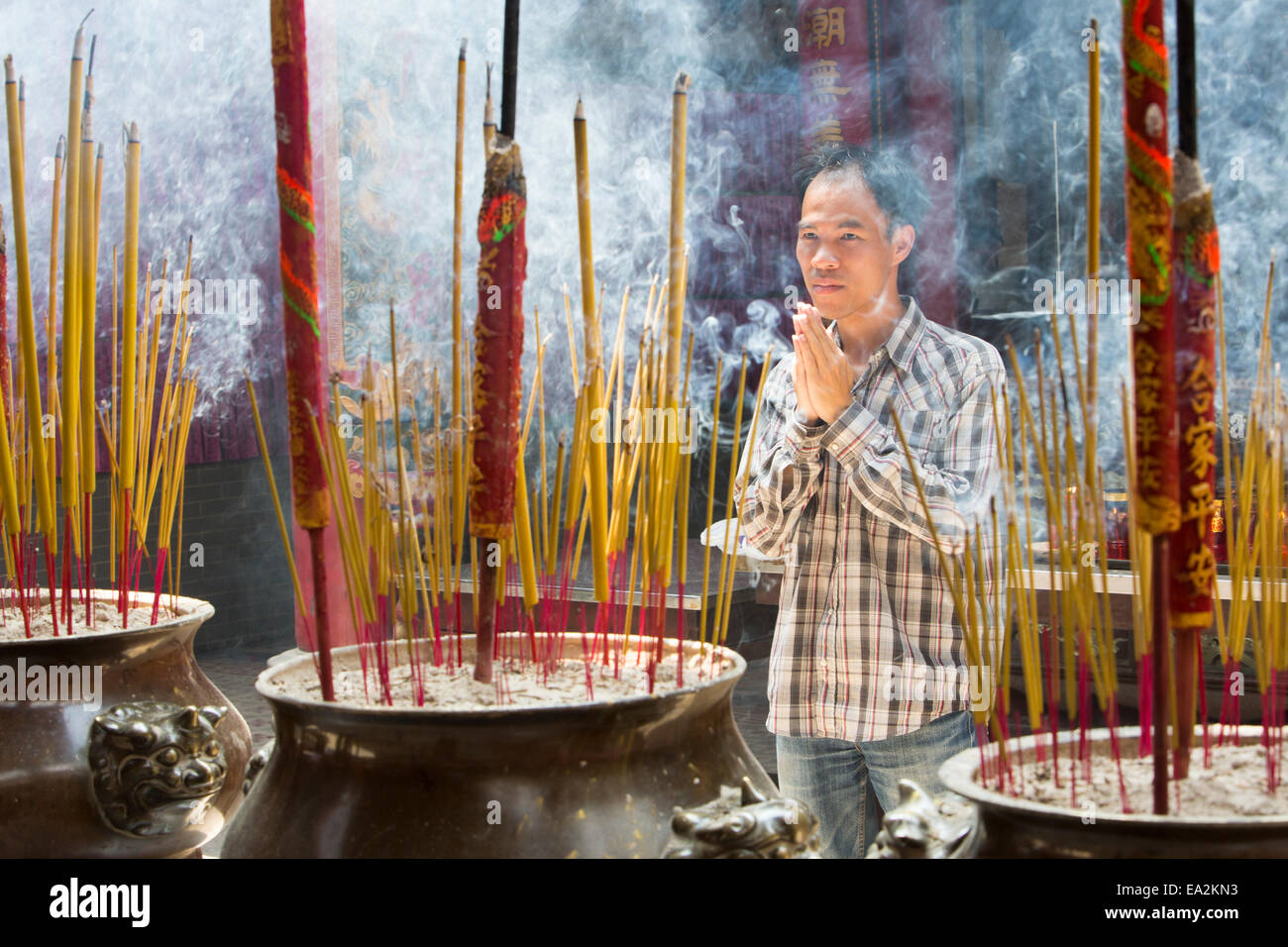 Man praying at Cantonese Pagoda with incense burning Stock Photo Alamy