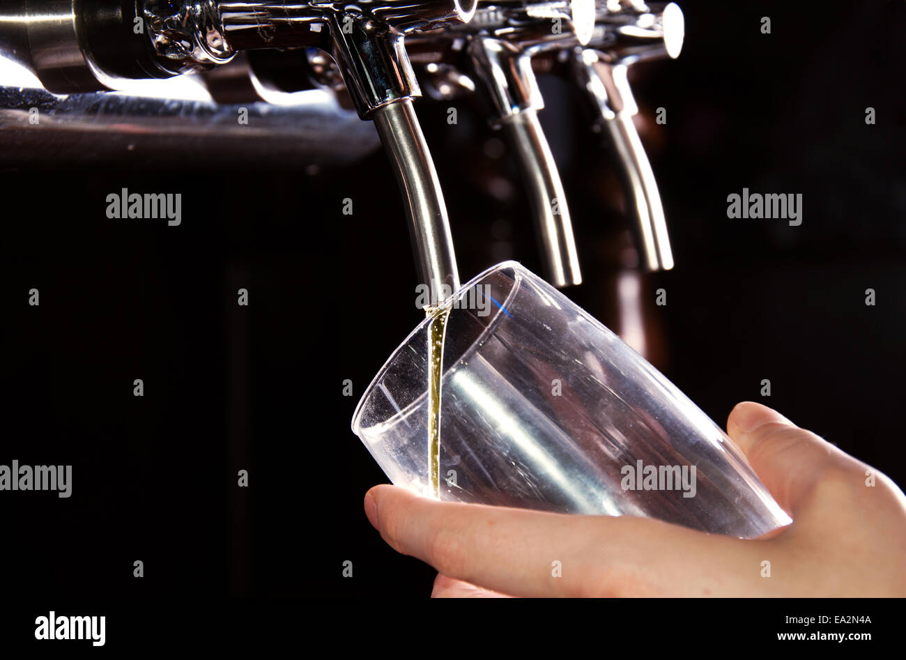 Alcohol conceptual image. Bartender giving the beer from dispenser. Stock Photo
