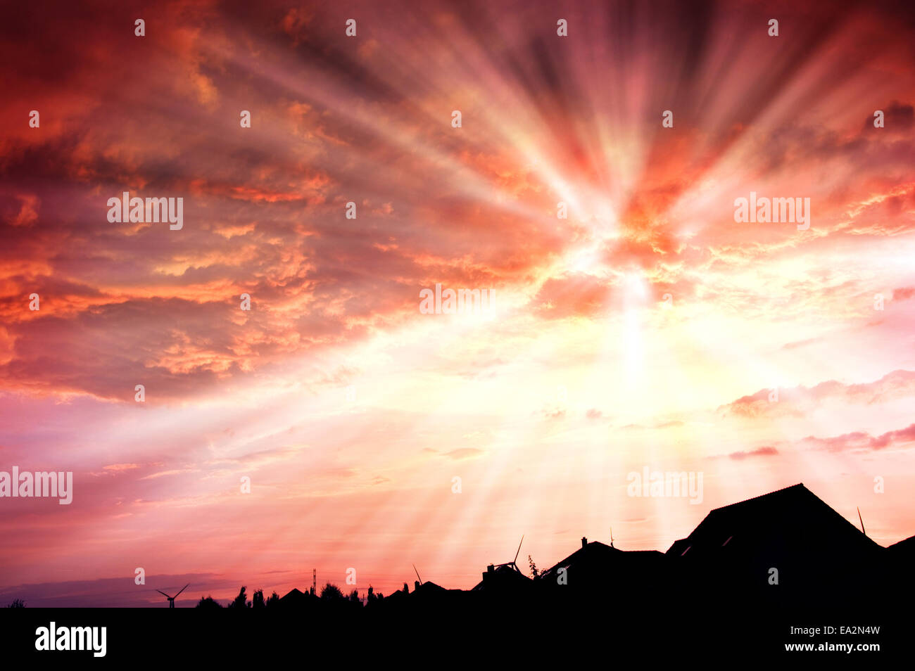 Sunset red sky with beams and dark dramatic clouds over houses Stock ...