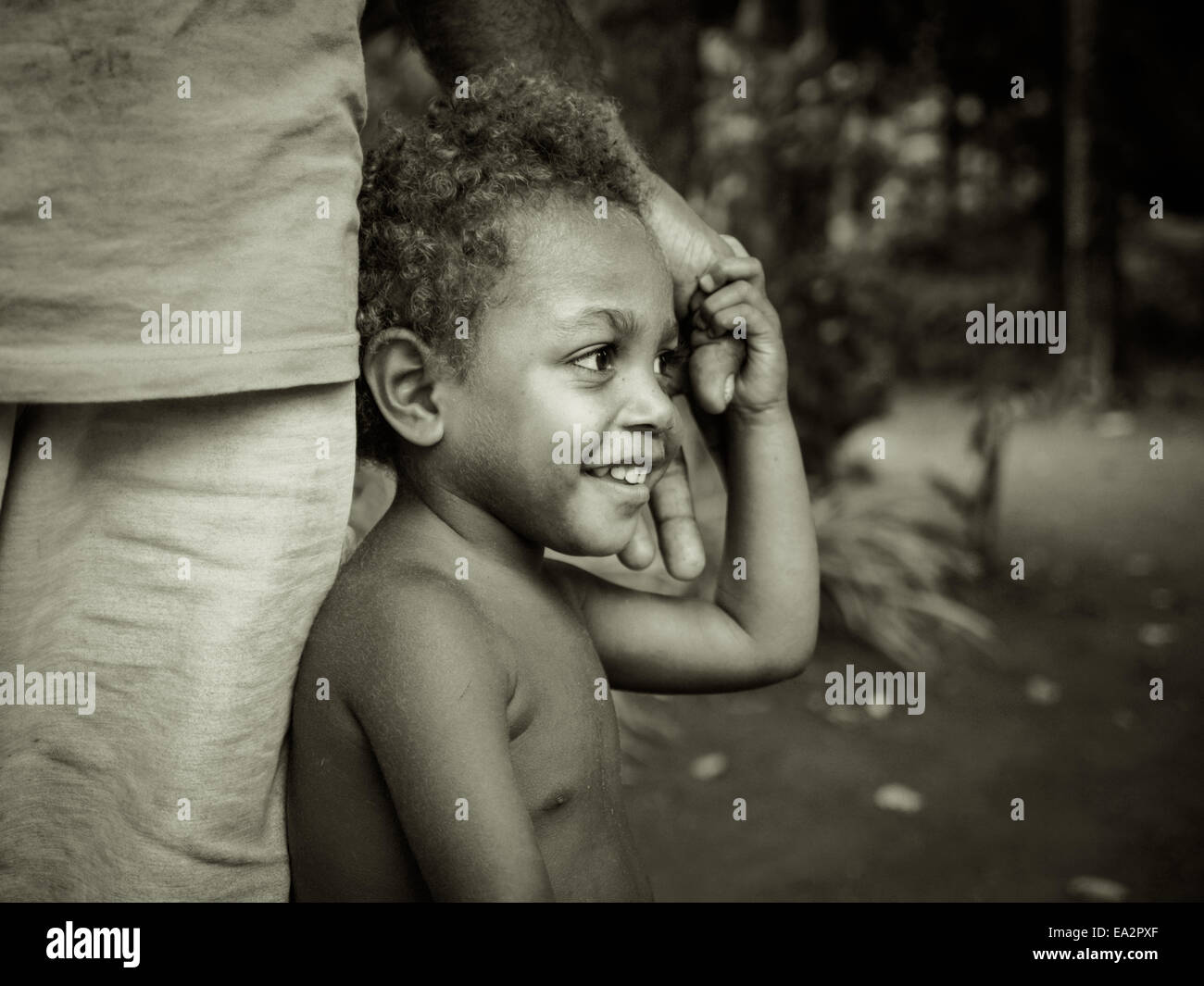 Adorable young ni-Vanuatu girl holding her father's hand Stock Photo