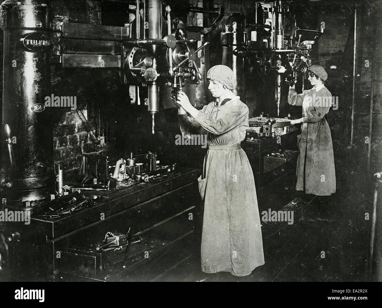 Women working on radial drills in an industrial setting, drilling valve covers and strainer plates for marine engine components. This image highlights women in manufacturing roles and their contributions to technical and engineering tasks. Stock Photo