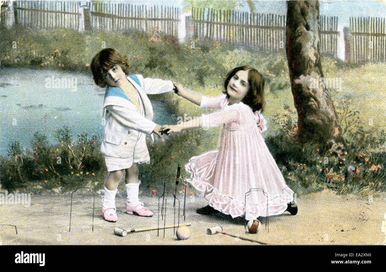 This image shows two children engaged in a game of croquet, capturing a