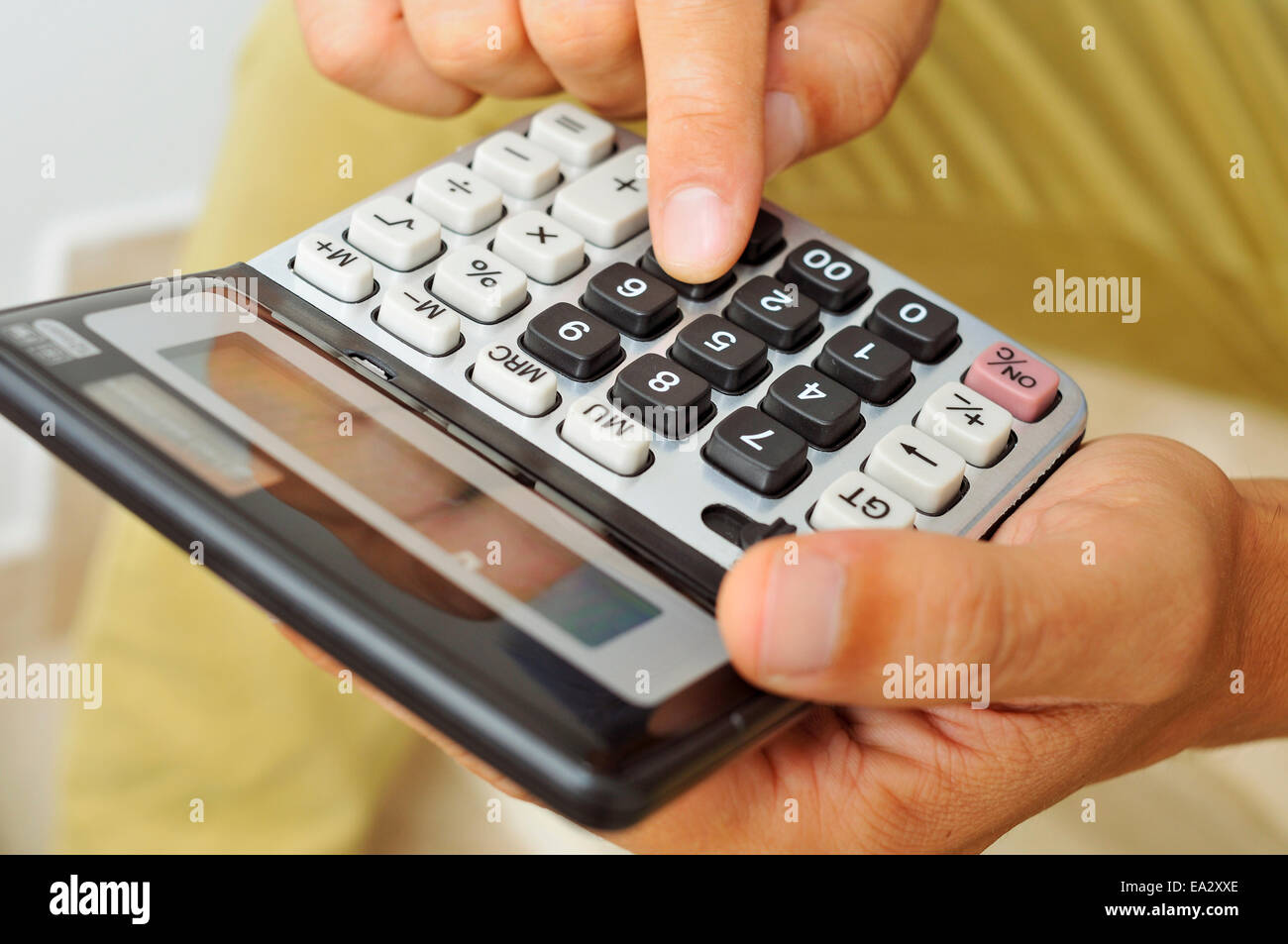closeup of a young man in casual wear using a calculator Stock Photo