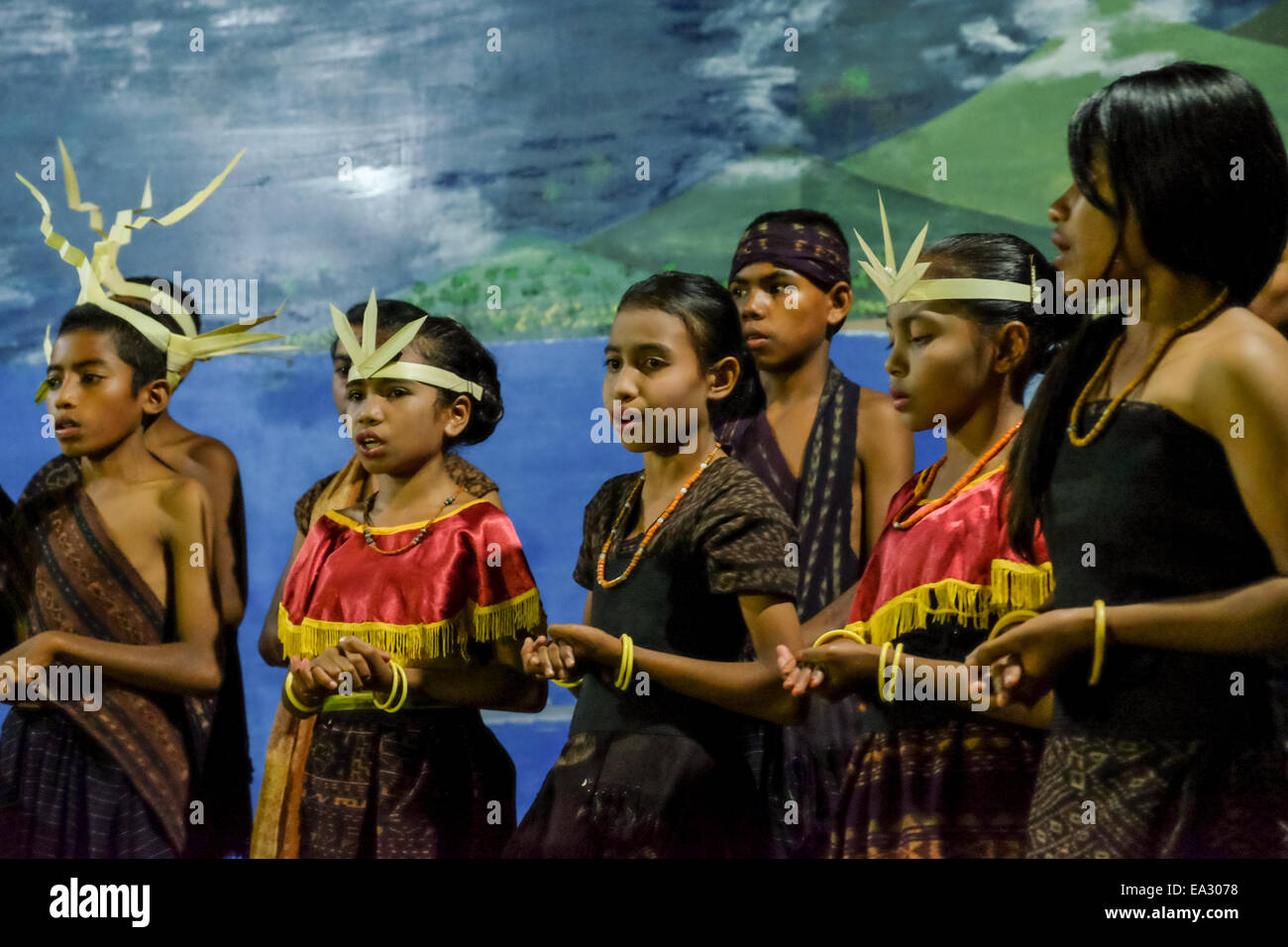 Children sing for guests at a traditional welcoming ceremony in Lamagute village, Lembata, Indonesia. Stock Photo