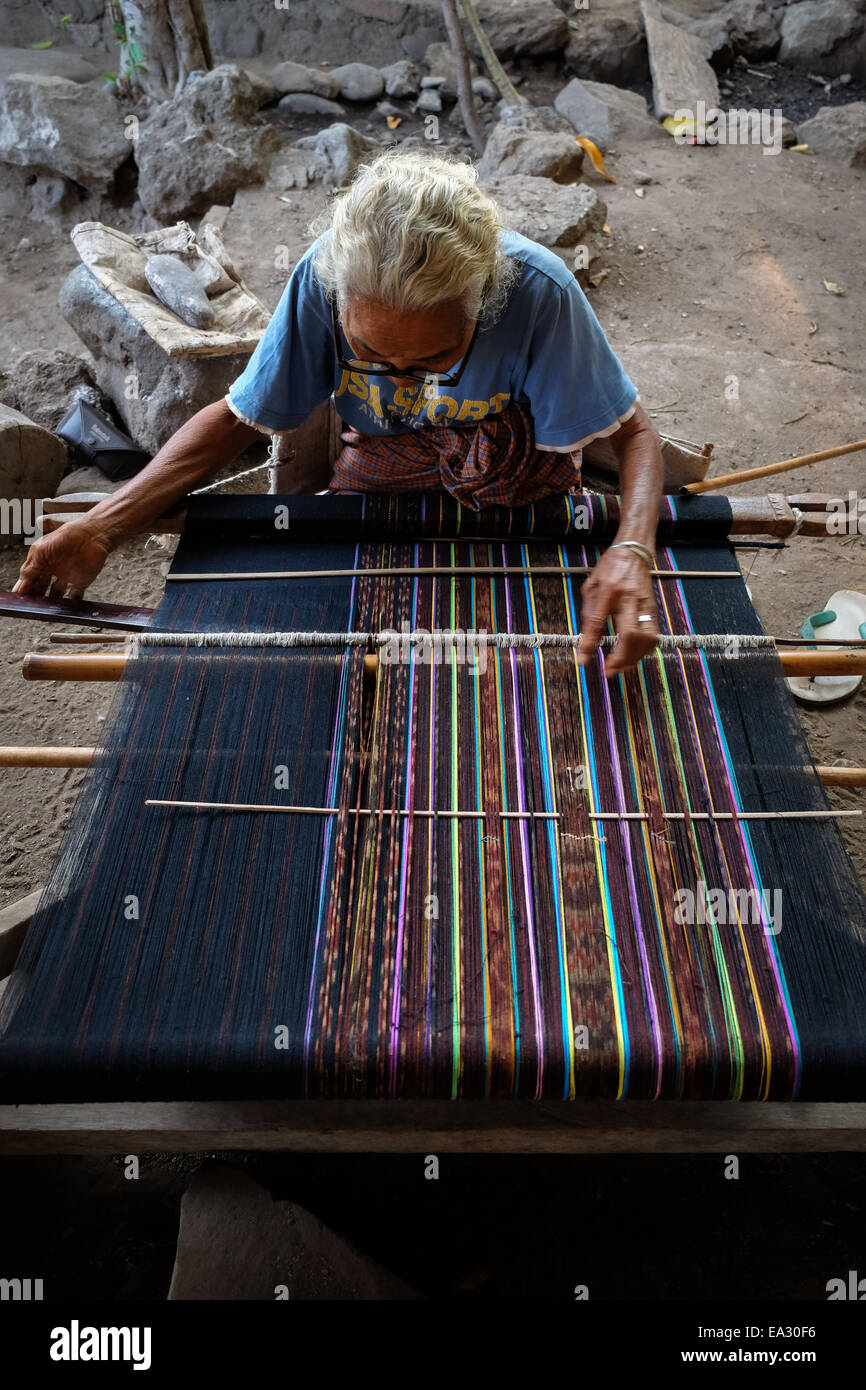 A woman weaving at her workshop--a traditional, alternative source of income in Lamagute village, Lembata, Indonesia. Stock Photo