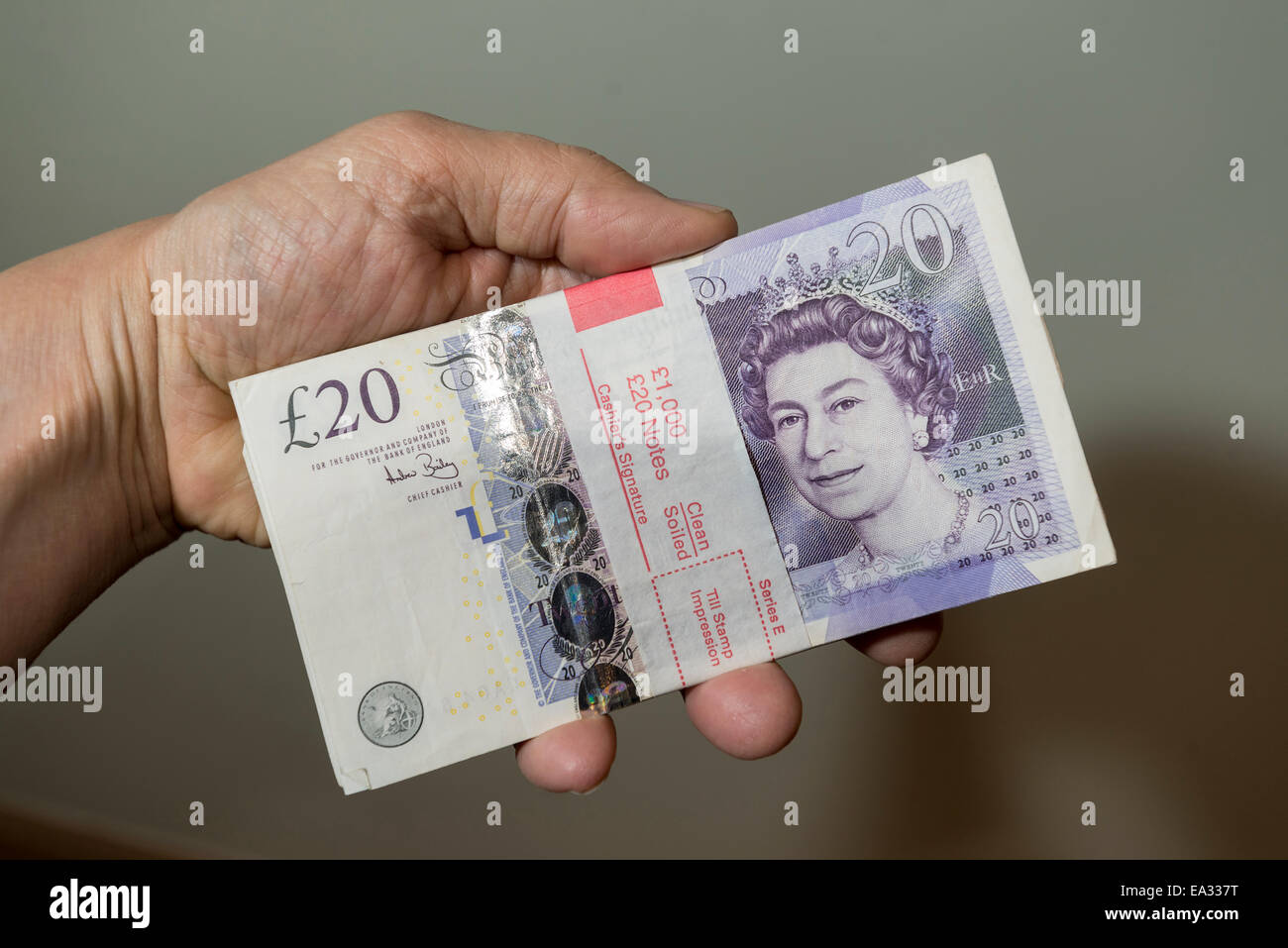 £1000 in £20 notes in a bank-wrapper held in a hand. Stock Photo