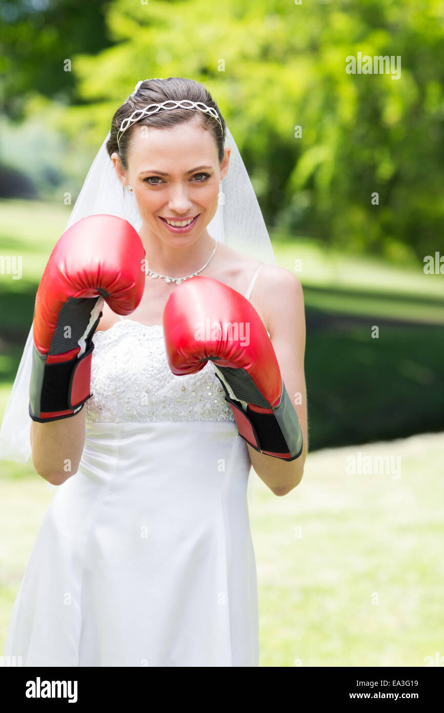Bride wearing boxing gloves in garden Stock Photo Alamy