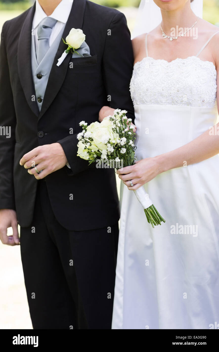 Bride and groom holding hands in park Stock Photo - Alamy