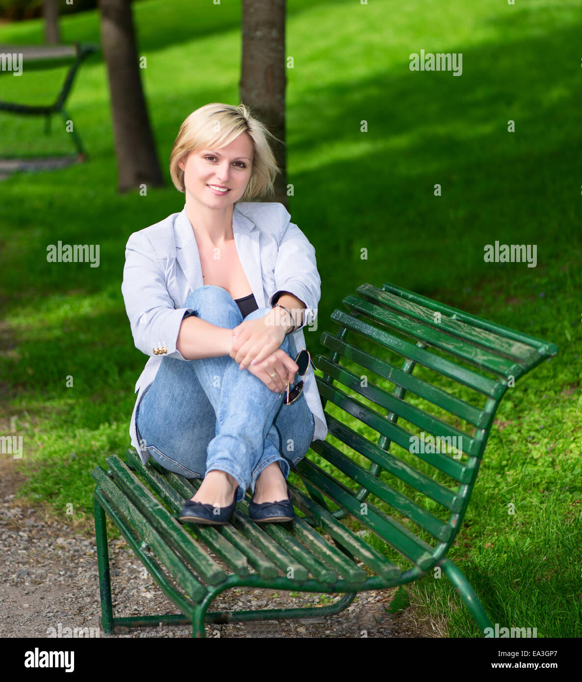 woman sitting on bench in park square Stock Photo - Alamy